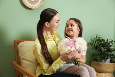 Anne ve kızı evde bir buket güzel şakayıkla