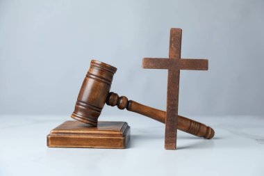 Yargıç tokmağı ve ahşap haç beyaz mermer masada