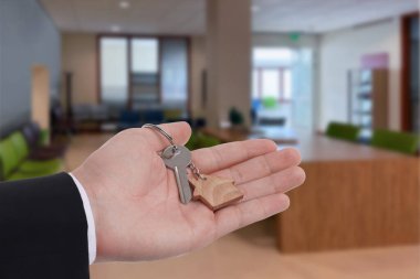 Emlakçı evin anahtarını tutuyor, yakın plan.
