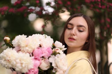 Şehir caddesinde elinde şakayık demeti olan bir kadın