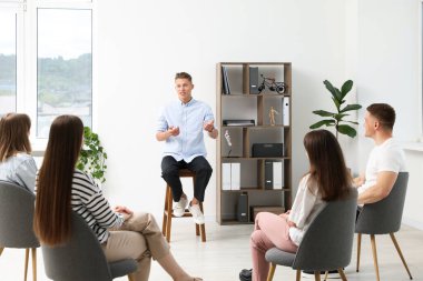 Yaşam koçluğu dersinde kapalı alanda toplantı yapan bir grup insan.