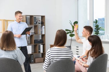 Yaşam koçluğu dersinde kapalı alanda toplantı yapan bir grup insan.