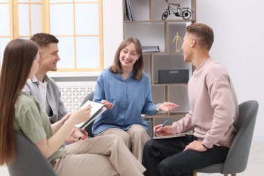 Yaşam koçluğu dersinde kapalı alanda toplantı yapan bir grup insan.