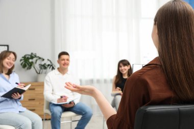 Yaşam koçluğu dersinde toplanan bir grup insan kapalı alanlarda seçici bir şekilde odaklanıyor.