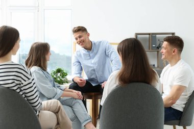 Yaşam koçluğu dersinde kapalı alanda toplantı yapan bir grup insan.