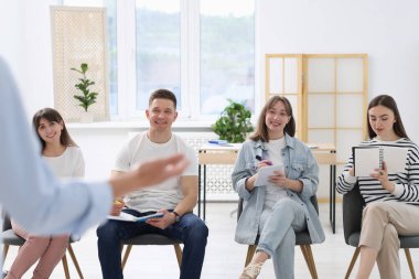 Yaşam koçluğu dersinde kapalı alanda toplantı yapan bir grup insan.