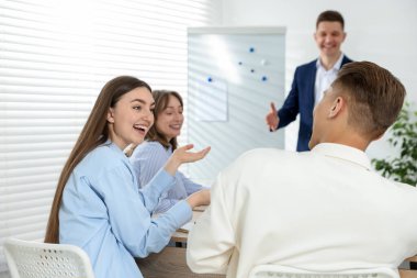 Yaşam koçluğu dersinde toplanan bir grup insan kapalı alanlarda seçici bir şekilde odaklanıyor.