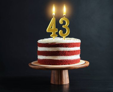 Siyah arka planda yanan mumlar olan lezzetli bir pasta. 43. yaş günü veya başka özel bir gün.