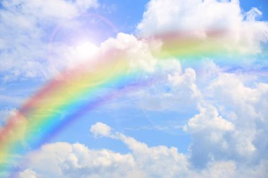 Mavi gökyüzünde parlak gökkuşağı güneşli bir günde bulutlarla