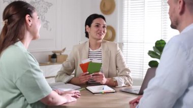 Ofisteki tahta masada seyahat acentesiyle tatil planlayan mutlu çift.