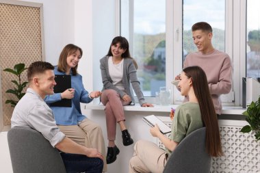 Yaşam koçluğu dersinde kapalı alanda toplantı yapan bir grup insan.
