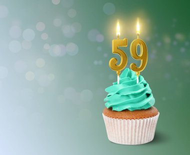 Turkuaz arka planda yanan mumları olan lezzetli bir kek. Mesaj için yer var. 59. yaş günü veya diğer özel günler