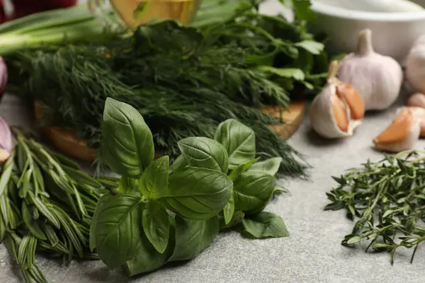 Gri masada farklı otlar ve baharatlar, yakın plan.