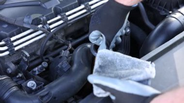 İşçi arabada motor yağı seviyesini dipstick ile kontrol ediyor.