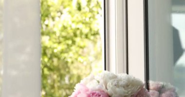 Pencere pervazındaki vazodaki güzel şakayıklar. Kamera aşağı iniyor