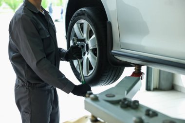 Tamirci araba servisinde lastik değiştiriyor, yakın plan.