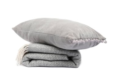 Katlanmış yün battaniye ve yastık beyaza izole edilmiş.