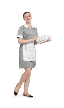 Beyaz arka planda temiz havlu yığını olan oda hizmetçisi.