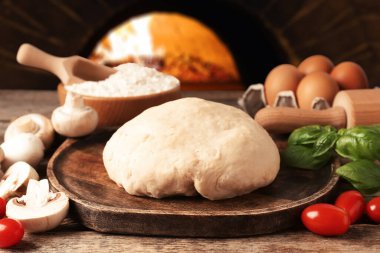 Pizza için taze malzemeler ahşap masada fırına karşı.