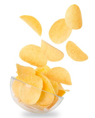 Lezzetli patates cipsleri beyaz arka planda kaseye düşüyor.