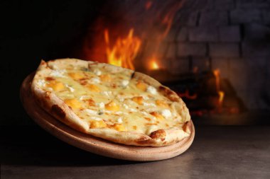 Gri masada fırına karşı nefis sıcak peynirli pizza.