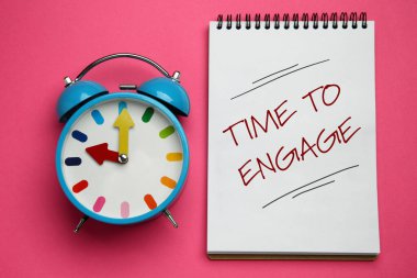 Pembe arkaplan üzerinde dizüstü ve alarm saati ile yazılmış cümleyi bağlama zamanı, üst görünüm