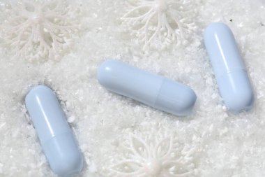 Nemlendirici dudak kremleri ve yapay karla süslenmiş Noel süsü. Kış bakımı