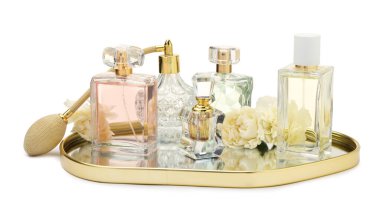 Birçok farklı parfüm şişeleri ve çiçekler beyaz üzerine izole edilmiş.