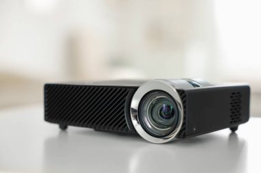 Beyaz masa üzerinde modern video projektörü, yakın plan.