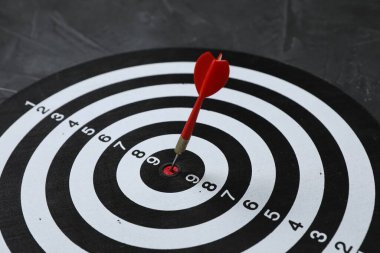 Hedef alınıyor. Gri arkaplanlı oklu dart tahtası, yakın plan