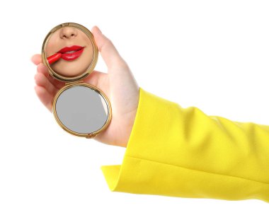 Güzel bir kadın beyaz arka plana kırmızı ruj sürerken aynaya bakıyor, yakın plan.