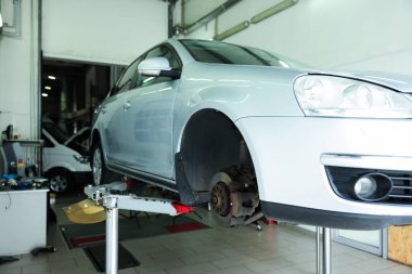 Araba servisinde lastik değiştirirken otomobili kaldırmış.