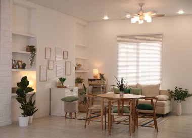 Odada rahat bir kanepe ve sandalyeli şık bir yemek masası. İç tasarım