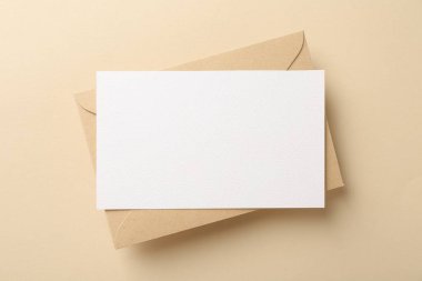 Bej arkaplanda boş davetiye ve zarf, üst görünüm