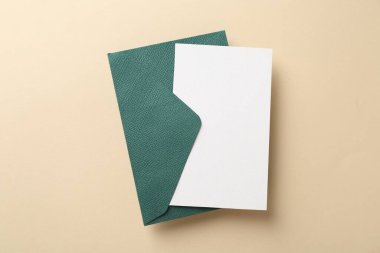 Bej arkaplanda boş davetiye ve zarf, üst görünüm