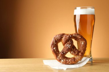 Lezzetli kraker ve bir bardak bira bej renkli arka planda, yakın plan. Metin için boşluk