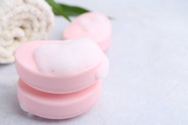 Beyaz masadaki köpüklü sabun çubukları, yakın plan. Metin için boşluk