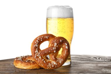 Lezzetli krakerler ve beyaz arka plana karşı ahşap masada bir bardak bira.