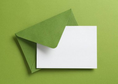 Yeşil arka planda boş davetiye ve zarf, üst manzara. Tasarım için boşluk