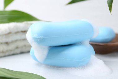 Beyaz masadaki köpüklü sabun çubukları, yakın plan.