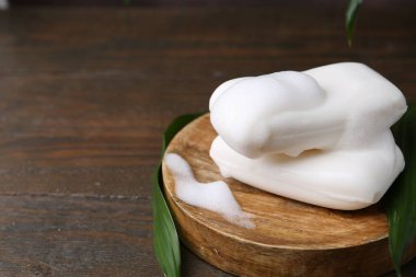 Köpüklü sabun çubukları, ahşap masa, yakın plan. Metin için boşluk