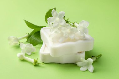 Açık yeşil arka planda sabun ve yasemin çiçekleri, yakın plan