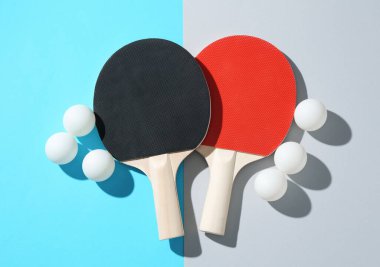 Ping pong rackets and balls on color background, flat lay