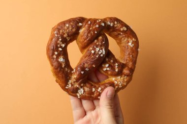 Turuncu arka planda lezzetli krakerli kadın, yakın plan.