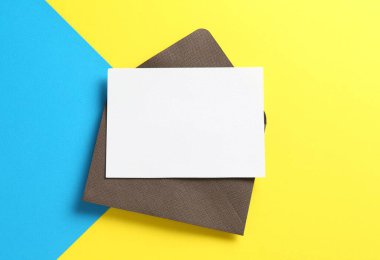 Renk arkaplan üzerinde boş davetiye ve zarf, üst görünüm. Tasarım için boşluk