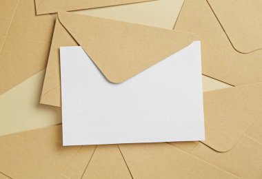 Boş davetiye kartı ve bej arka planda zarflar, düz yatış. Tasarım için boşluk