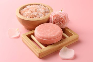 Sabun barı, deniz tuzu ve pembe arka planda güzel bir gül, yakın plan.