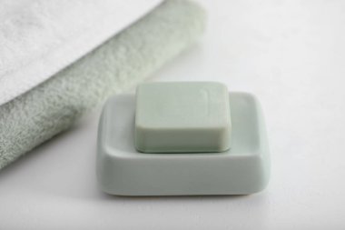 Sabun çubuğu ve havlular beyaz masada, yakın plan.