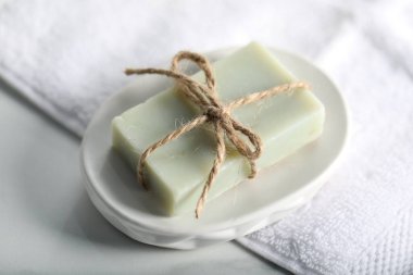 Sabun çubuğu ve havlu beyaz masada, yakın plan.