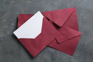 Boş davetiye kartı ve zarflar gri masada, düz yatıyordu